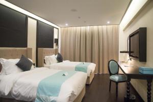 a hotel room with two beds and a desk and a chair at Xana Hotelle Suqian Soho Ginza Branch in Suqian