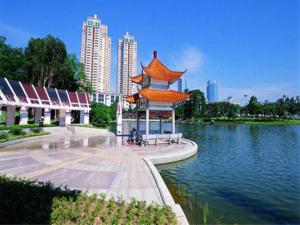a pagoda in the middle of a lake in a city at Xana Lite Jiangmen Yingbin West in Jiangmen