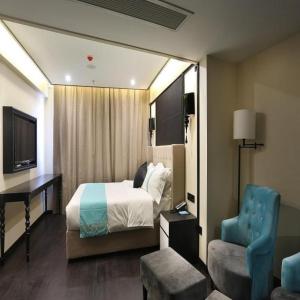 a hotel room with a bed and a desk and a chair at Xana Hotelle Suqian Soho Ginza Branch in Suqian