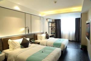 a hotel room with two beds and a window at Xana Lite Jiangmen Yingbin West in Jiangmen
