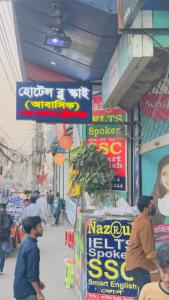 a group of people walking around a market with signs at Hotel Blue Sky Mirpur in Dhaka