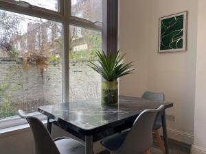 a dining room table with chairs and a potted plant at Family Home With Parking in Liverpool