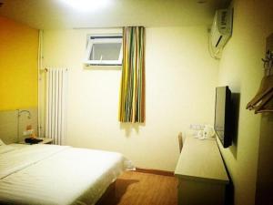 Habitación de hotel con cama y ventana en 7 Days Inn Tianjin South Railway Station, en Chaomidian