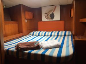 Una cama en un barco con dos toallas. en Boat & Breakfast Sorrento sailing, en Castellammare di Stabia