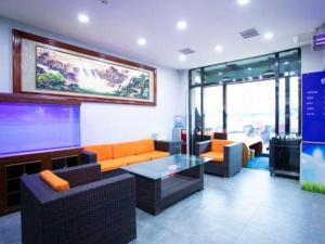 a living room with couches and a large screen tv at 7 Days Inn Tianjin Binhai Passenger Station Huabei Ceramics in Binhai