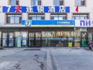 濱海的住宿－7 Days Inn Tianjin Binhai Passenger Station Huabei Ceramics，上面有蓝白色标志的建筑