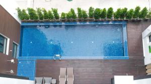 a large blue swimming pool with potted plants on top at The High One in Ban Laem Thaen
