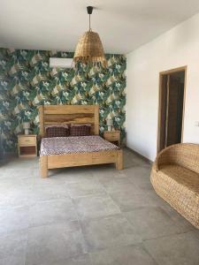 1 dormitorio con cama de madera y silla en villa de standing, en Sali Nianiaral