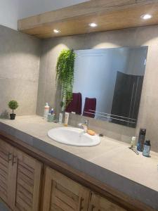 a bathroom counter with a sink and a mirror at villa de standing in Sali Nianiaral
