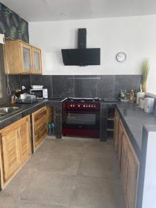 a kitchen with wooden cabinets and a red stove at villa de standing in Sali Nianiaral