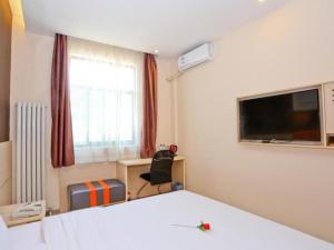 a bedroom with a bed and a tv and a desk at 7 Days Premium Jinan Gaoxin Qu Wanda Plaza in Hongjialou