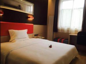 7 Days Premium Jinan Gaoxin Qu Wanda Plaza في Licheng: غرفة نوم مع سرير أبيض كبير مع اللوح الأمامي الأحمر