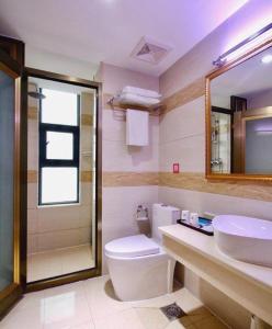 a bathroom with a toilet and a sink and a mirror at Pai Hotel Dujiang Yanxujia Gaoqiao in Dujiangyan