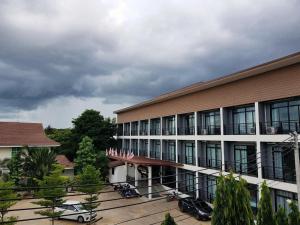 a large building with cars parked in front of it at Pornsiri Hotel Sisaket in Si Sa Ket
