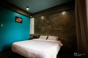 a bedroom with a large bed with a blue wall at Pornsiri Hotel Sisaket in Si Sa Ket