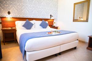 - une chambre d'hôtel avec un lit et un plateau de nourriture dans l'établissement Relais Villa Giuliana, à Licata