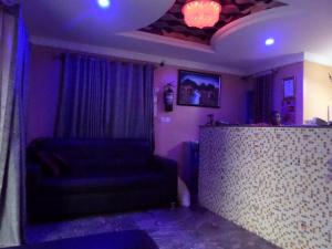 fioletowy pokój z kanapą i barem w obiekcie Jimson International Hotel and Suites w mieście Ijapo