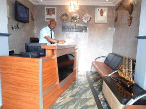 a man standing at a counter in a room at Euro Lounge and Suites in Adegbite