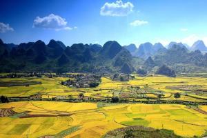 an aerial view of a field with mountains in the background at 7 Days Inn Xingyi Wanfenglin Xiawutun in Xiawutun