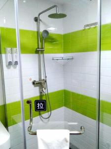 7 Days Inn Xingyi Wanfenglin Xiawutun في Xiawutun: حمام مع دش عليه بقع خضراء وبيضاء