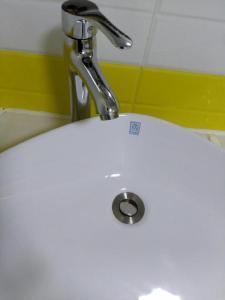 7 Days Inn Xingyi Wanfenglin Xiawutun في Xiawutun: بالوعة بيضاء مع صنبور في الحمام