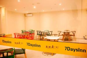a group of tables and chairs in a room at 7 Days Inn Changbai Mountain Beipo in Baomacheng