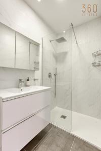 een witte badkamer met een wastafel en een douche bij Designer 3BR home with Private Balcony in Gzira by 360 Estates in Il-Gżira