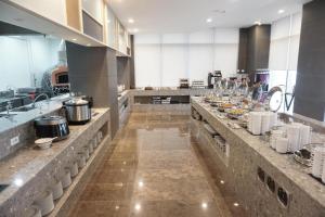 a large kitchen with a long counter with dishes at The Artstay Seogwipo Harbor in Seogwipo