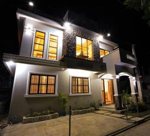 a large white house with lit up windows at night at Hillside Villa in Basco