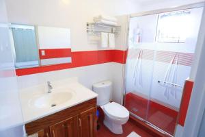 a bathroom with a toilet and a sink and a shower at Hillside Villa in Basco