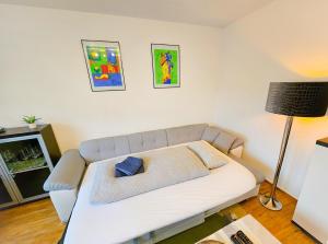 un sofá blanco en una sala de estar con lámpara en Exklusive Ferienwohnung in Meppen, en Meppen