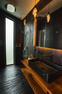 een badkamer met een zwarte wastafel en een spiegel bij Aurora Cabins by Panoramika in Jatiluwih