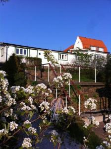 una casa con flores blancas delante de ella en Cottage by the ocean, en Ängelholm