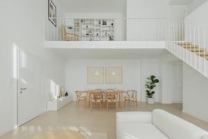 a white living room with a table and chairs at Blanc Residences in Ioannina