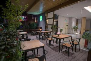 Dapengchengにあるdanfeng kelly hotelの木製のテーブルと椅子が置かれた空のレストラン