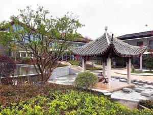 a gazebo with a roof in a park at Tiantai He hotel in Tiantai