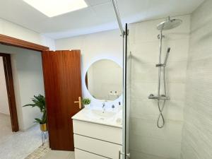 a bathroom with a sink and a shower with a mirror at La Paloma del Pilar ComoTuCasa in Zaragoza