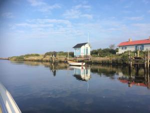 a boat in the water next to a house at Cottage by the ocean in Ängelholm