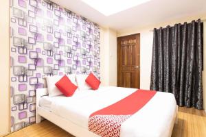 - une chambre avec un lit blanc et des oreillers rouges dans l'établissement OYO 128 d'Builders Rooms Phase 2, à Manille