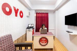 a woman sitting at a desk with a laptop at OYO 128 d'Builders Rooms Phase 2 in Manila