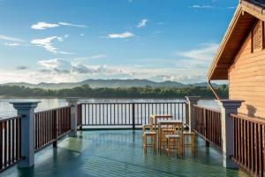 清康的住宿－BankongRimkhong Chiangkhan，阳台配有桌椅,享有河景