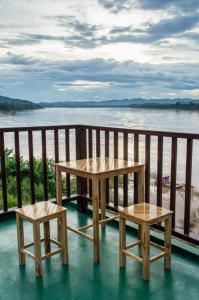 stół i 2 stołki na balkonie z widokiem na wodę w obiekcie BankongRimkhong Chiangkhan w mieście Chiang Khan