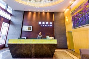 Longtansi的住宿－Lavande Hotels Chengdu University of Technology，站在大厅柜台上的人