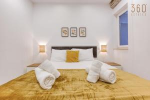 een slaapkamer met een groot bed en handdoeken bij Designer 3BR home with Private Balcony in Gzira by 360 Estates in Il-Gżira