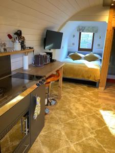 a room with a kitchen and a bedroom with a bed at Little London Bed & Breakfast and Glamping pod in Abercraf