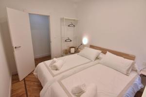 1 dormitorio con 1 cama grande con sábanas y almohadas blancas en Atseden Bilbo, en Bilbao