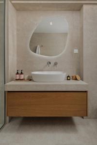 a bathroom with a sink and a mirror at Blanc Residences in Ioannina