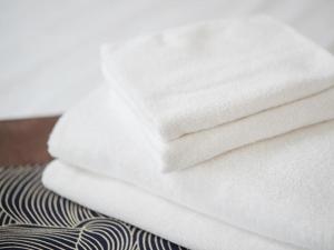 une pile de serviettes blanches assises sur un lit dans l'établissement Cielo Unten, à Kouri