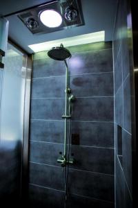 a shower stall in a bathroom with a light at James Joyce Coffetel·Chengde Mountain Resort Toudao Pailou in Shuiquangou