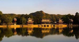 un lac avec deux bâtiments chinois au milieu dans l'établissement James Joyce Coffetel·Chengde Mountain Resort Toudao Pailou, à Chengde
